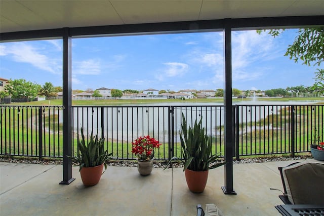 sunroom / solarium featuring a water view
