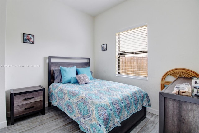 bedroom featuring baseboards and wood finished floors
