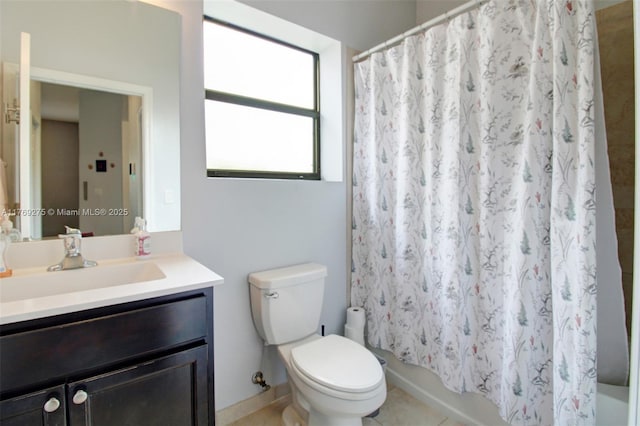full bathroom featuring toilet, vanity, shower / bath combo with shower curtain, and tile patterned flooring