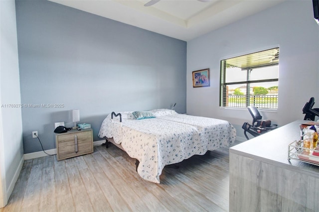 bedroom featuring light wood-style floors and baseboards