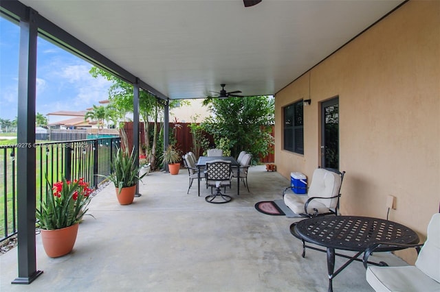 view of patio / terrace with outdoor dining area, fence, and ceiling fan