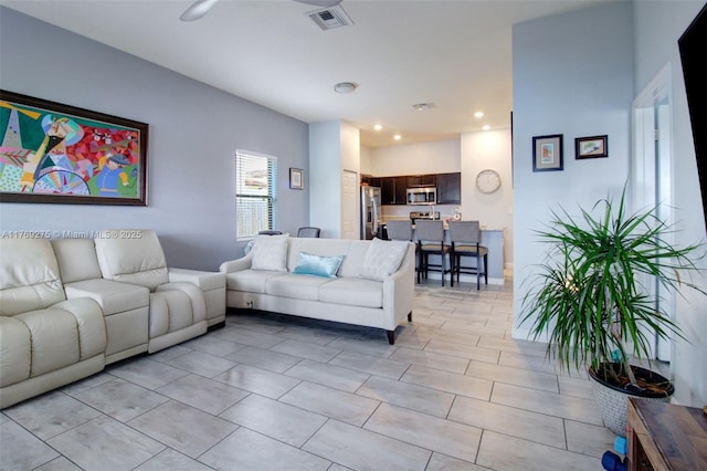 living room with baseboards, light tile patterned flooring, and ceiling fan