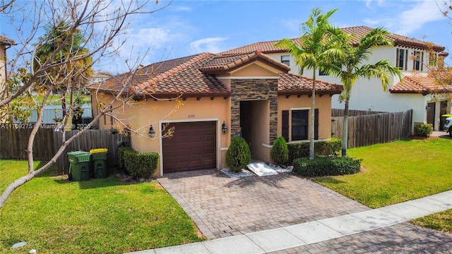mediterranean / spanish-style house with a garage, a tile roof, stucco siding, a front lawn, and decorative driveway