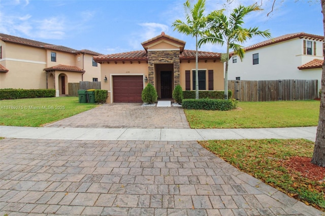 mediterranean / spanish home featuring a tiled roof, stucco siding, and decorative driveway