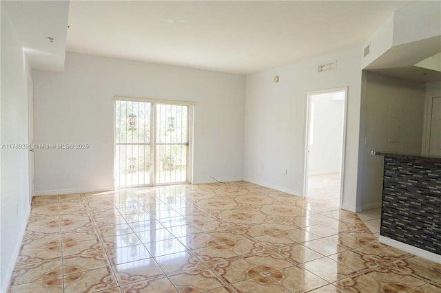spare room featuring visible vents and baseboards