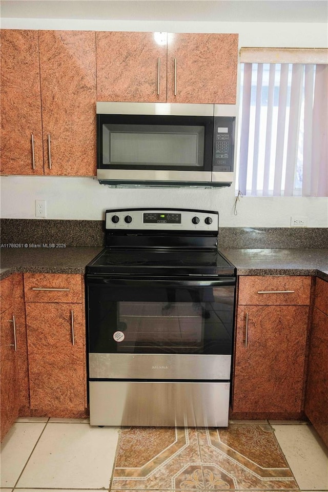 kitchen featuring dark countertops, brown cabinets, and appliances with stainless steel finishes