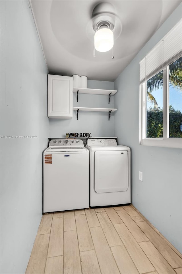 laundry room with cabinet space, ceiling fan, washer and dryer, and light wood finished floors