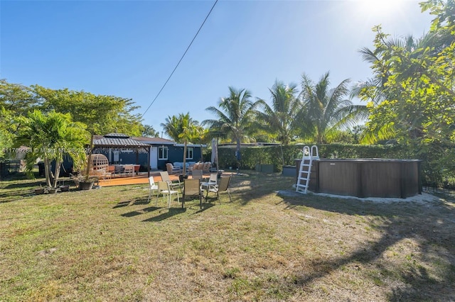 view of yard with a gazebo, a deck, and a pool