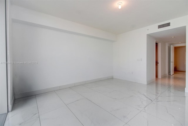 spare room with visible vents, marble finish floor, and baseboards
