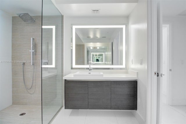 bathroom with tile patterned floors, visible vents, vanity, and a walk in shower
