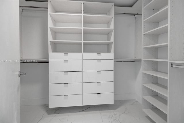 walk in closet featuring marble finish floor