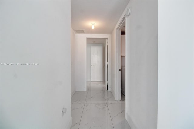 corridor featuring marble finish floor, baseboards, and visible vents
