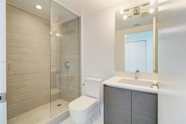 full bath with toilet, vanity, and a stall shower