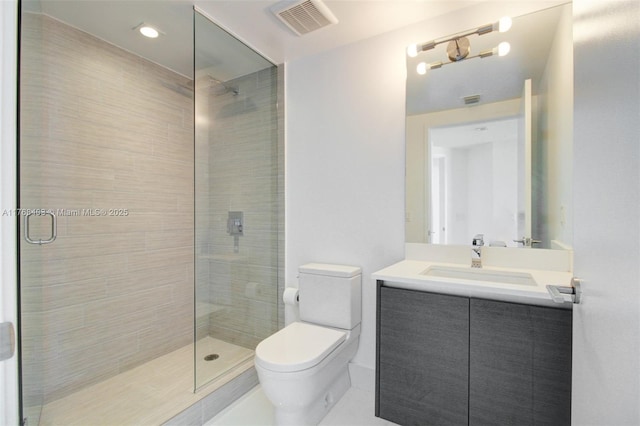 full bathroom featuring vanity, toilet, a stall shower, and visible vents