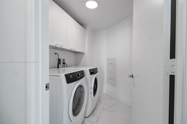 clothes washing area with cabinet space, washing machine and clothes dryer, marble finish floor, and baseboards