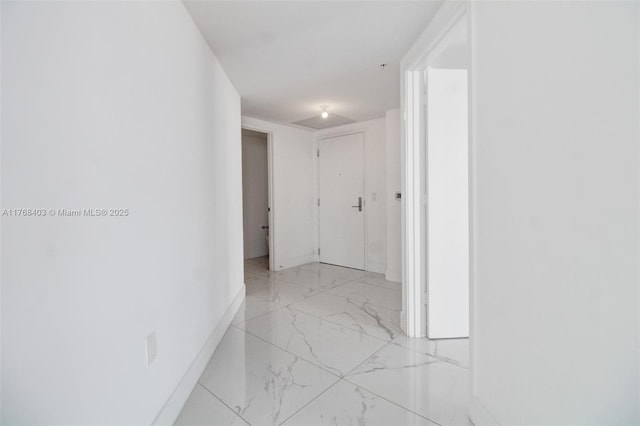 hallway with marble finish floor and baseboards