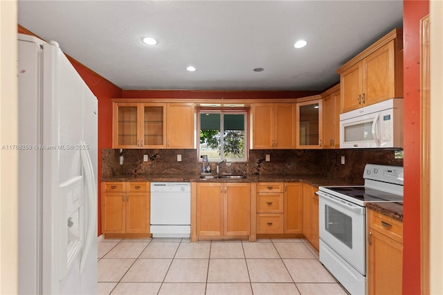 kitchen featuring a sink, glass insert cabinets, light tile patterned floors, white appliances, and decorative backsplash