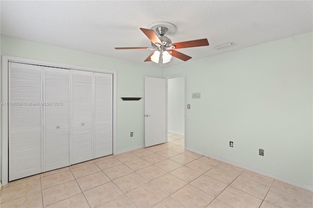 unfurnished bedroom featuring light tile patterned flooring, a textured ceiling, a closet, and visible vents