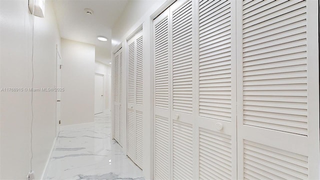 hall with marble finish floor and recessed lighting