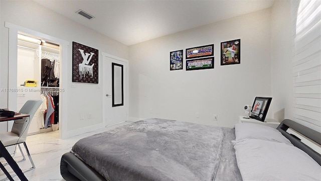 bedroom featuring a spacious closet, marble finish floor, a closet, and visible vents
