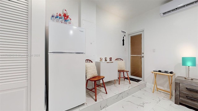 kitchen with radiator, an AC wall unit, baseboards, marble finish floor, and freestanding refrigerator