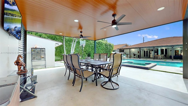 view of patio with outdoor dining area, a pool with connected hot tub, and a ceiling fan