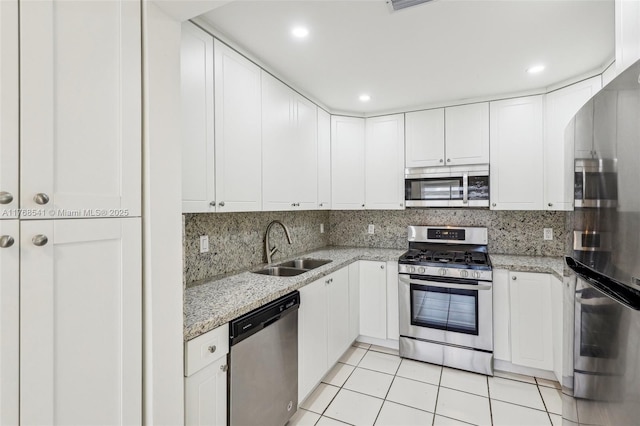 kitchen featuring light tile patterned flooring, tasteful backsplash, a sink, and stainless steel appliances