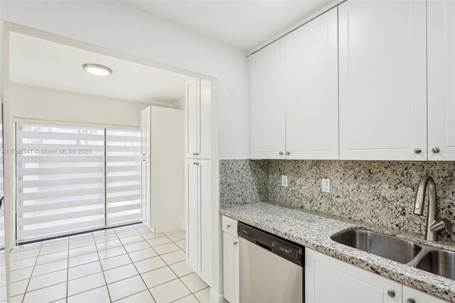 kitchen featuring decorative backsplash, light tile patterned flooring, dishwasher, white cabinetry, and a sink