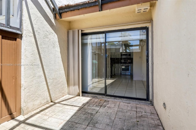 property entrance with stucco siding