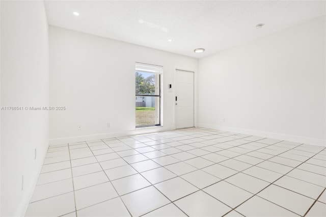 spare room featuring baseboards, recessed lighting, and light tile patterned floors