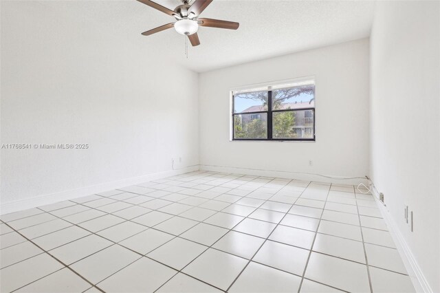 unfurnished room with light tile patterned floors, baseboards, ceiling fan, and a textured ceiling