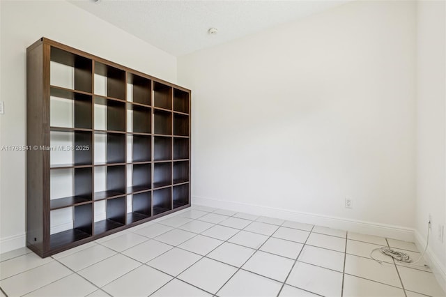 unfurnished room featuring tile patterned flooring and baseboards