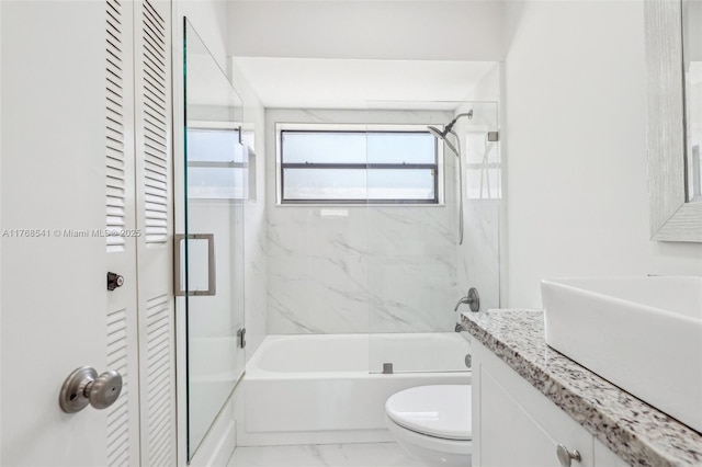 bathroom with a closet, toilet, vanity, shower / bathtub combination, and marble finish floor