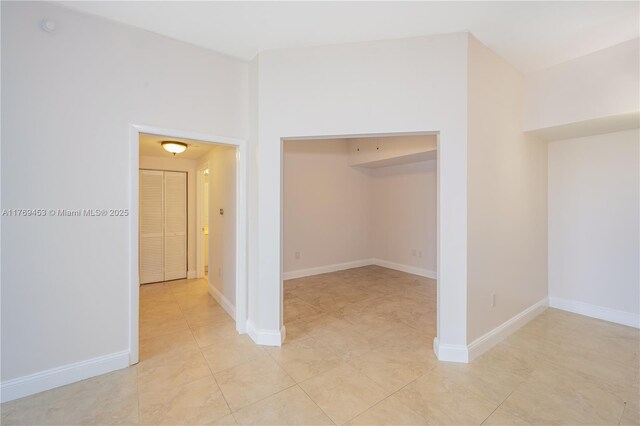 interior space with light tile patterned floors and baseboards