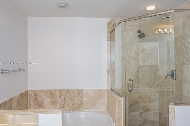 bathroom with a shower stall and a bath
