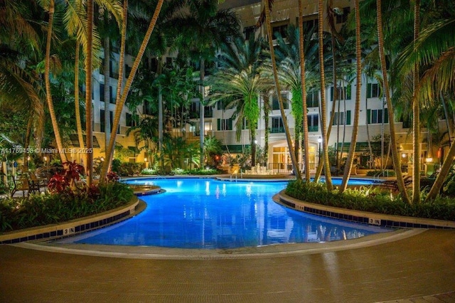 pool at twilight featuring a community pool