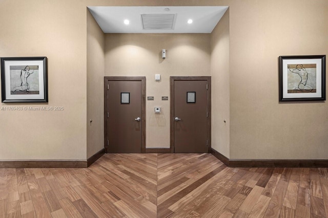 foyer entrance with wood finished floors and baseboards