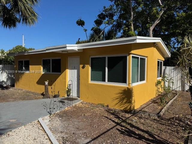 1025 NE 3rd Ave, Fort Lauderdale, FL 33304 - view of front of home with stucco siding and fence