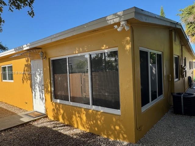 1025 NE 3rd Ave, Fort Lauderdale, FL 33304 - view of side of home with central AC unit and stucco siding