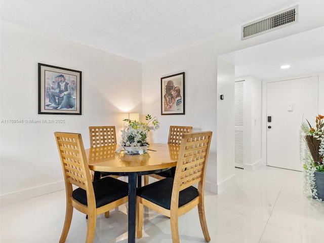 200 Diplomat Pkwy Unit 424, Hallandale Beach, FL 33009 - dining area with baseboards, visible vents, light tile patterned floors, and a textured ceiling