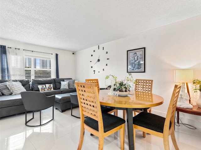 200 Diplomat Pkwy Unit 424, Hallandale Beach, FL 33009 - dining space featuring light tile patterned flooring, baseboards, and a textured ceiling