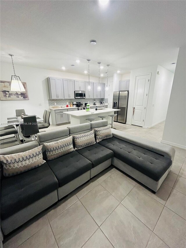 living room with light tile patterned flooring, a textured ceiling, baseboards, and recessed lighting