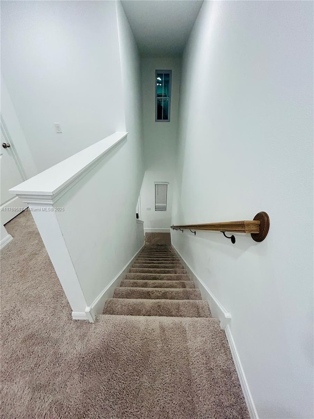 stairs featuring baseboards and carpet flooring