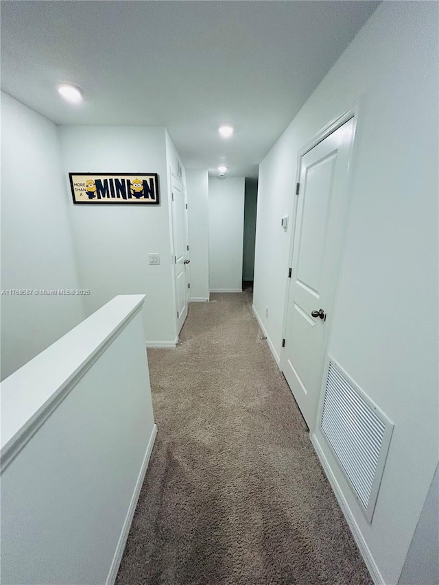 corridor with light carpet, baseboards, and visible vents