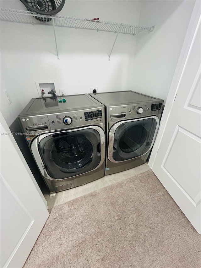 laundry room with carpet floors, separate washer and dryer, and laundry area