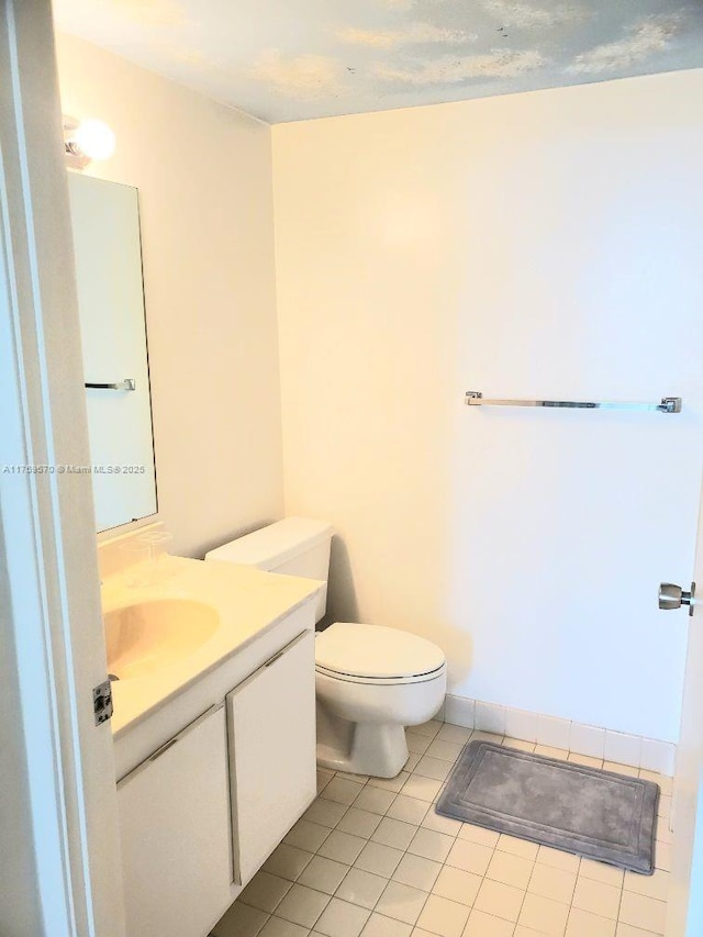 bathroom featuring tile patterned flooring, vanity, and toilet
