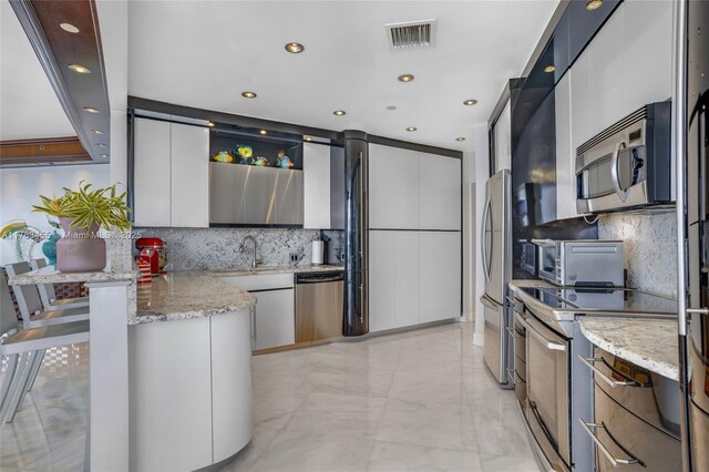 4000 Island Blvd Unit Ph6, Aventura, FL 33160 - kitchen featuring a toaster, a sink, visible vents, a peninsula, and appliances with stainless steel finishes