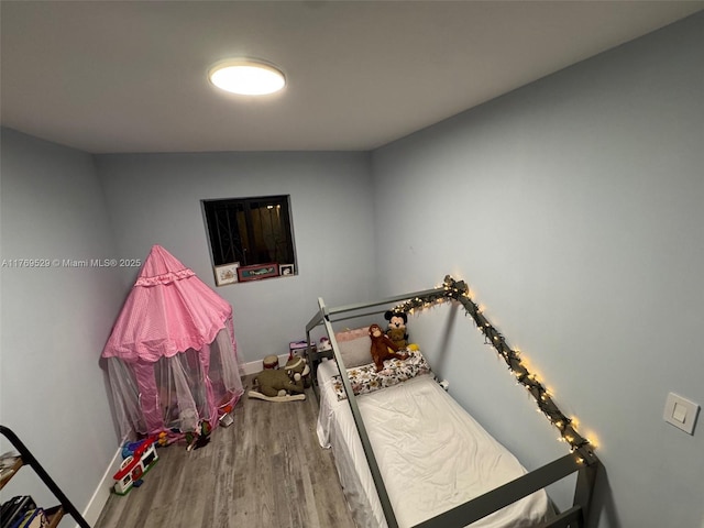 bedroom with wood finished floors and baseboards