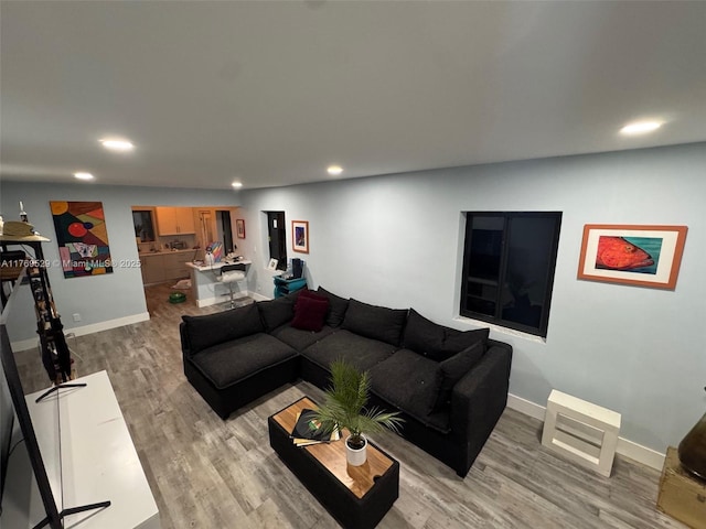 living room featuring recessed lighting, light wood-type flooring, and baseboards