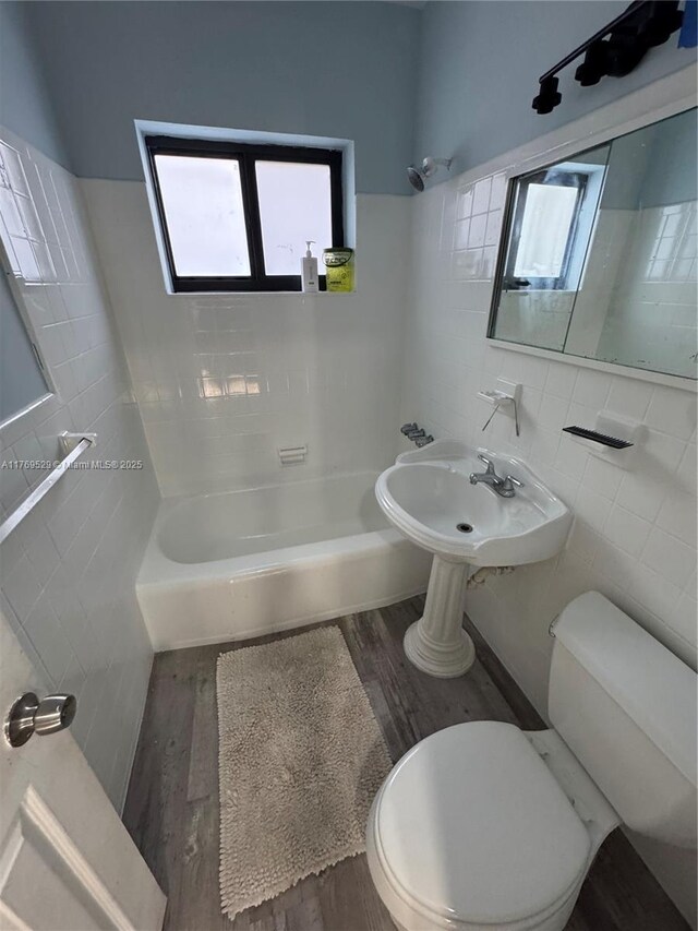 440 E 37th St, Hialeah, FL 33013 - bathroom with tile walls, toilet, plenty of natural light, wood finished floors, and  shower combination